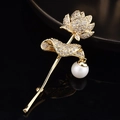 Détail de la broche fleur de lotus dorée avec cristaux de zircon et une perle blanche ronde - Style Perle Lotus Doré
