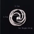 Dettaglio della spilla a spirale argentata con cristalli bianchi e perla grigia - Vortice