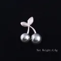 Detailed macro view of cherry flower brooch with matte silver leaves and grey pearls - Cherry