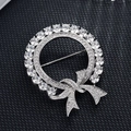 Vue détaillée d'une broche couronne argentée avec zircons et nœud sur tissu noir - Nœud Papillon Rond