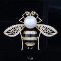 Exquisite goldene Bienenbrosche mit weißer Perle und Zirkonflügeln auf schwarzem Samt - Gold