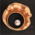 Macro shot of matte gold alloy brooch with white pearl and wave texture detailing - Shell Pearl