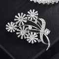 Détail macro d'une broche bouquet avec zircons clairs sur fond en cuir noir - Cinq Fleurs