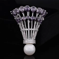 Dettaglio macro della spilla da badminton con zirconi viola e perla bianca su fondo nero - Tono Argento Zirconia Viola