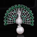 Detail of peacock brooch with green zircons and a large white pearl on black background - Silver Green Zirconia