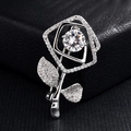 Détail d'une broche rose argentée avec pavage de zircons fins et cristal central brillant - Rose