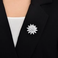 Primer plano de broche de copo de nieve con circonitas en la solapa de un traje negro - Oro Blanco