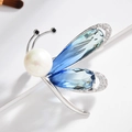 Elegante spilla a insetto con cristalli blu, perle bianche e zirconi su sfondo bianco - Blu Sfumato