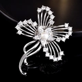 Gros plan d'une broche fleur en argent avec zircons et une perle blanche au centre - Ruban De Fleurs De Prunier