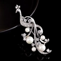 Macro detail of elegant peacock brooch with white pearls and sparkling zircons - Phoenix