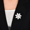Elegante spilla a fiore argento con zirconi e perla sul bavero di una giacca nera - Argento
