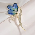 Detalle del broche de flor con pétalos de cristal azul y hojas de circonita - Oro Azul