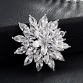 Gros plan sur une broche fleur élégante avec zircons marquise sur cuir noir texturé - Tournesol Argent