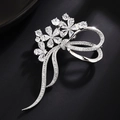 Détail de la broche fleur argentée avec cristaux de zircone et design de ruban noeud - Style Zircone Transparente / Or Blanc