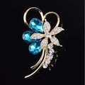 Golden flower brooch with teardrop blue crystals and white cubic zirconia accents - Bow Blue