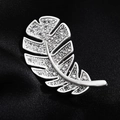 Eleganter silberner Blatt-Anstecknadel mit Zirkonia-Besatz auf dunklem Stoffhintergrund - Mattsilber