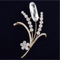 Eleganter vergoldeter Blumen-Broschen-Pin mit funkelnden Kristallen auf schwarzem Samt - Weiß