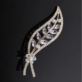 Eleganter goldener Haarclip in Blattform mit funkelnden Strasssteinen auf schwarzem Hintergrund - Lila Orchideenblatt