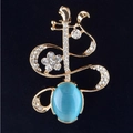 Elegante spilla a forma di strumento musicale dorata con occhio di gatto blu e cristalli - Arpa