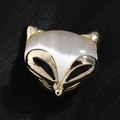 Elegante broche de zorro dorado con piedra ojo de gato blanca sobre tela texturizada negra - Dorado