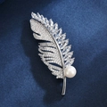 Eleganter Feder-Anstecknadel mit Zirkonia und Perle auf dunkelblauem Hintergrund - Silber