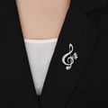 Dettaglio della spilla a nota musicale argento con cristalli scintillanti su un blazer nero - Argento