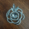 Detail of elegant silver alloy rose brooch with intricate rhinestone leaf and petal inlay - Large Silver Flower Style