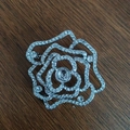 Detail shot of a silver rose brooch base with sparkling rhinestones on a dark surface - Rose Beaded Style
