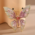 Elegant gold-plated butterfly brooch with pink and red zircon stones on a soft pink stand - Red