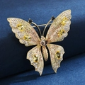 Elegant gold butterfly brooch with multicolored zircons on a navy velvet background - Yellow