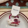 Détail d'un chouchou mouton en peluche blanche avec nœud rouge sur une assiette décorative - [7] Élastique à Cheveux Agneau Rouge
