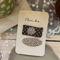 Détail de barrettes en tissu faites main avec pois et motifs floraux sur carte - Barrettes Carrées Coussin Pois