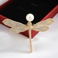 Elegant gold dragonfly brooch featuring white crystal wings and a large round pearl - Dragonfly Gold