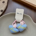 Détail de chouchous cœur en tissu bleu avec broderie Love jaune et petits pompons - Élastique Cœur Bleu