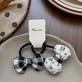 Detail of classic plaid and floral bow hair ties on a minimalist display plate - Checkered And Floral Bow Hair Ties