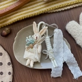 Detail of handmade rabbit keychain with lace dress, heart clasp, and pearl ribbon decor - Lace Rabbit Style
