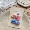 Détail de barrettes étoile en peluche avec sourires brodés et petits pompons - Pinces à Cheveux Étoile Rose et Bleu