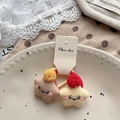 Detaillierte Makroansicht von zwei sternförmigen Plüsch-Haargummis mit süßen Smileys - Gelb und Kaffee Stern Haargummis