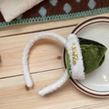 Detail of white plush Christmas headband with green velvet mini hat and gold Merry text - Green Christmas Hat Style