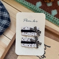 Vista dettagliata di due fermagli per capelli in tessuto crema a pois su carta vintage - Clip Capelli Fiocco Nero Quadrato