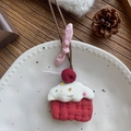 Dettaglio di un ciondolo cupcake in tessuto fatto a mano con base rossa e ciliegia su piatto - Collana Torta di Ciliegie