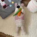 Detail of handmade wool knitted bunny doll with carrot in a cozy home setting - Knitted Carrot Rabbit Doll