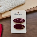Détail de pinces à cheveux en feutre bordeaux avec broderie flocon et nœud doré - Pince à Cheveux Broderie Flocon Ovale