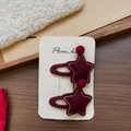 Détail de barrettes étoiles en feutre rouge avec surpiqûres roses sur carte - Pince à Cheveux Étoile Pompon