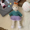 Detail of handmade crochet amigurumi doll with orange bow and colorful knitted clothes - Knitted Blue Sweater Girl Doll