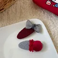 Vue macro détaillée de barrettes à cheveux en tricot rouge fait main avec ruban et texture - Pince à Cheveux Nœud et Pompon Ovale