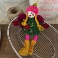 Dettaglio di un ciondolo fata fatto a mano in feltro di lana con vestito verde e rosa - Ciondolo Bambola Fata Vestito Verde