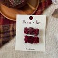 Detail view of handmade candy-shaped plaid hair clips on white display card - Candy Bow Knot
