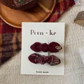 Detail of red plaid and wine red bow hair clips with gold heart charms on display card - Plaid Knotted Bowknot