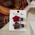 Close-up of handmade star-shaped plaid fabric hair clips in vintage retro school style - Pompom Star